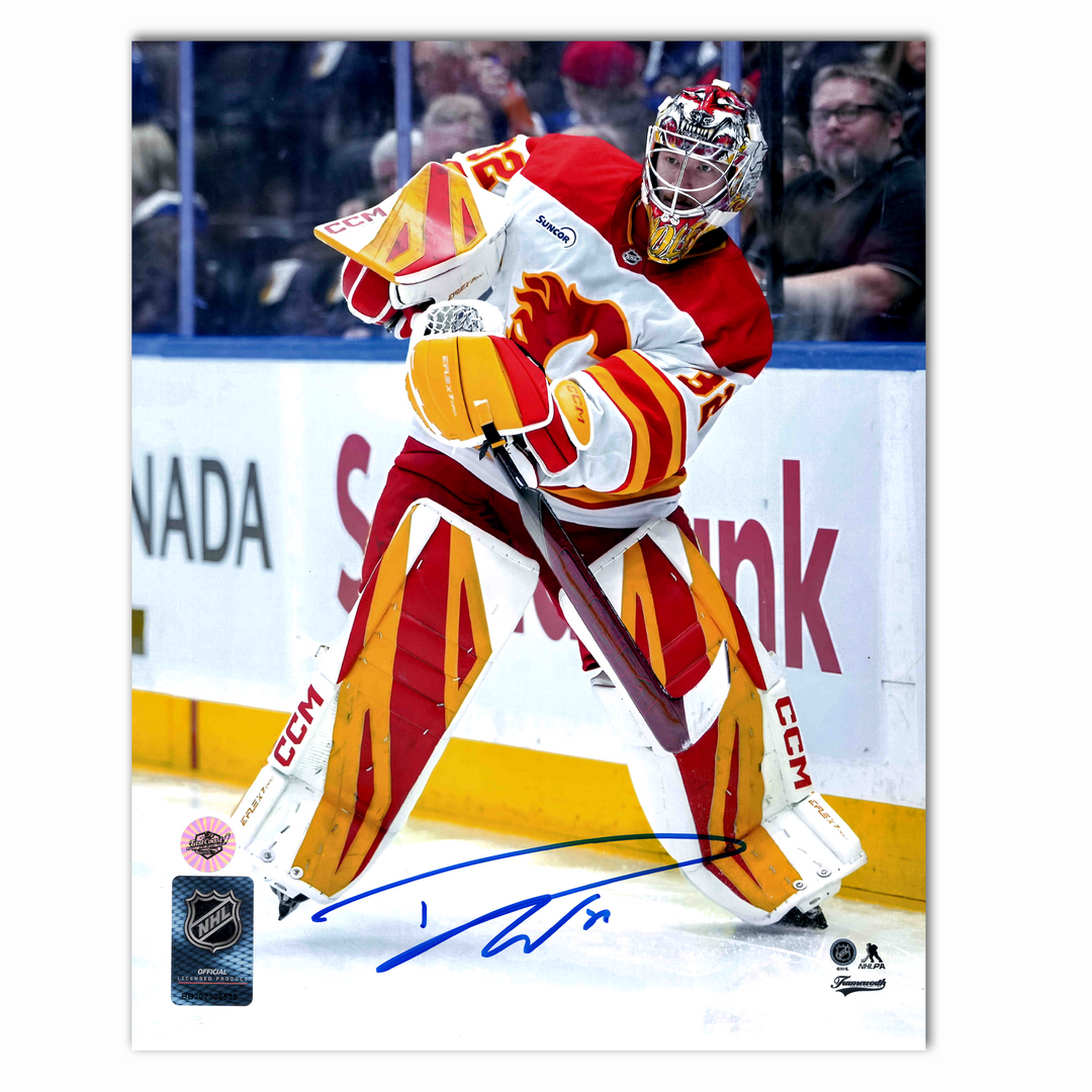 Dustin Wolf Autographed Calgary Flames Clearing Puck 8x10 Photo